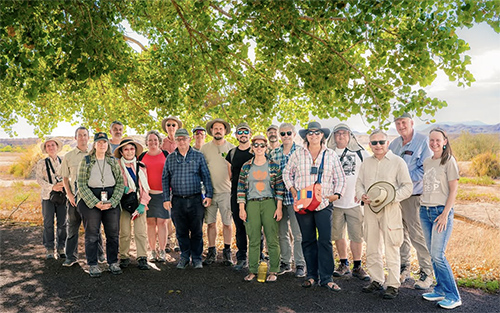 a group of people standing outside in the bosque